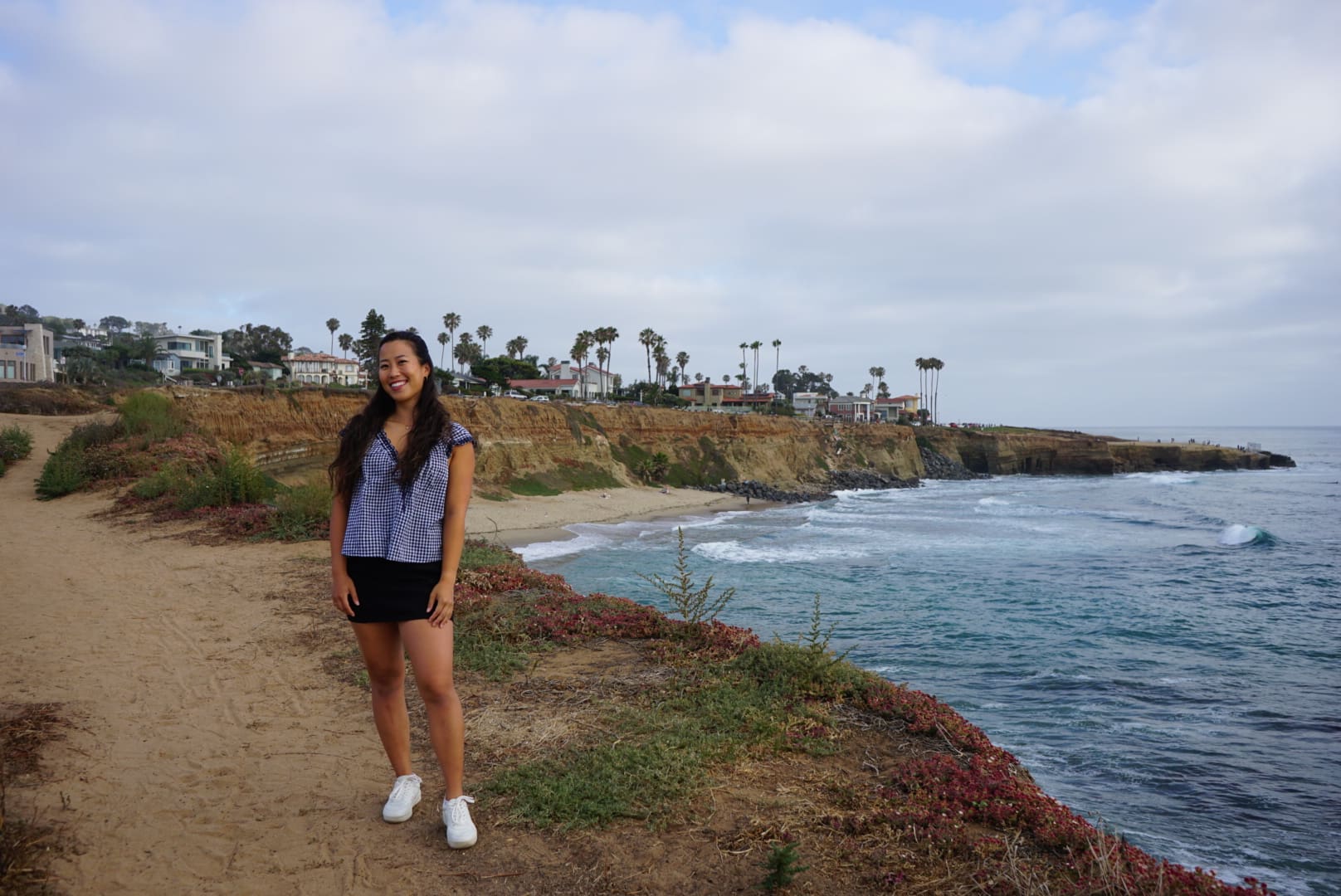 girl standing at a beautiful cliffside view of the ocean in san diego